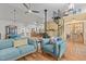 Cozy living room with blue sofas, wood floors, and view into farmhouse kitchen with spiral stairs at 381 Reams Dr, Middlesex, NC 27557