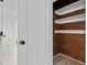 Walk-in closet with wood-paneled walls and built-in white shelves at 405 N Hyde Park Ave, Durham, NC 27703