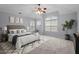 Spacious bedroom features a ceiling fan, arched windows and a large rug over neutral carpeting at 414 Travertine Dr, Cary, NC 27519