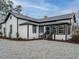 Exterior of a house with gray gravel, white siding, black trim, metal roof and landscaping at 416 E Fremont St, Kenly, NC 27542