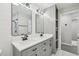 Bright bathroom featuring a double vanity, modern fixtures, and sleek gray cabinets at 4436 Talcott Dr, Durham, NC 27705