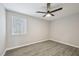 Bedroom with a ceiling fan, natural light from a window, and sleek gray wood flooring at 4436 Talcott Dr, Durham, NC 27705