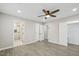 Open bedroom area showcasing gray wood flooring, ceiling fan, closet, and en suite bathroom at 4436 Talcott Dr, Durham, NC 27705
