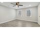 Bedroom featuring a modern ceiling fan, natural light from two windows, and gray wood flooring at 4436 Talcott Dr, Durham, NC 27705