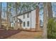 Back side view of two-story white house with black trim and a chimney, with trees in the background at 4436 Talcott Dr, Durham, NC 27705