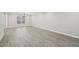 A large living room featuring gray wood flooring, natural light, and white trim at 4436 Talcott Dr, Durham, NC 27705