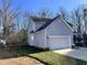 Side view of home, featuring two car garage and manicured lawn, surrounded by trees at 4904 Goosedown Ct, Raleigh, NC 27604