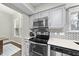 Kitchen detail showcasing stainless steel appliances, herringbone backsplash, and light gray cabinetry at 5 Bonham Ct, Durham, NC 27703