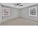 Bright bedroom with two windows, neutral paint, carpet, and a ceiling fan at 5002 Kendridge Dr, Durham, NC 27712