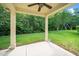 Covered back patio features a ceiling fan and a view of the lush, green backyard with a swing set at 532 Front Ridge Dr, Cary, NC 27519