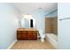 Well-lit bathroom featuring double sinks, tub with tile surround, and ceramic tile floors at 532 Front Ridge Dr, Cary, NC 27519