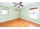 Well-lit bedroom with hardwood flooring, ceiling fan, and three large windows with custom blinds at 532 Front Ridge Dr, Cary, NC 27519