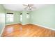 Well-lit bedroom with hardwood flooring, ceiling fan, and three large windows at 532 Front Ridge Dr, Cary, NC 27519