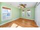 Bright bedroom with hardwood floors, a ceiling fan, and abundant natural light from the windows at 532 Front Ridge Dr, Cary, NC 27519