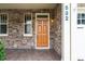 Inviting covered front porch with stone accents, warm lighting, and tiled flooring at 532 Front Ridge Dr, Cary, NC 27519