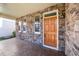 Inviting front porch featuring stone accents, an orange front door, and stylish exterior lighting at 532 Front Ridge Dr, Cary, NC 27519