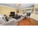 Virtually staged living room with hardwood floors, a fireplace, and neutral furniture at 532 Front Ridge Dr, Cary, NC 27519
