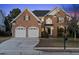 Charming brick two-story home featuring an attached two-car garage and manicured lawn at 9132 Sanctuary Ct Ct, Raleigh, NC 27617