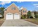 Classic brick two-story home with a two-car garage, complemented by a well-maintained lawn at 9132 Sanctuary Ct Ct, Raleigh, NC 27617