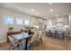 Open-concept dining area flowing into a modern kitchen with stainless steel appliances and breakfast bar seating at 15 Merle Dr, Wendell, NC 27591