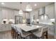Open-concept kitchen featuring an island with barstool seating, modern appliances, and stylish lighting at 15 Merle Dr, Wendell, NC 27591