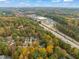 Expansive aerial view of neighborhood with lush tree cover, highway, and retail at 10 Marchmont Ct, Durham, NC 27705
