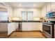 Bright kitchen featuring stainless steel appliances, granite countertops, white cabinets, and hardwood floors at 10 Marchmont Ct, Durham, NC 27705