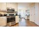 Modern kitchen with stainless steel appliances, granite counters, and a built-in desk area at 10 Marchmont Ct, Durham, NC 27705