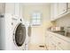 Functional laundry room with front loading washer and dryer, a utility sink, and storage cabinets at 10 Marchmont Ct, Durham, NC 27705
