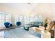 Spacious living room with large windows, blue accents, and a ceiling fan at 10 Marchmont Ct, Durham, NC 27705