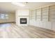 Living room showcasing luxury vinyl plank flooring, a fireplace, and custom built-in shelving at 10 Marchmont Ct, Durham, NC 27705