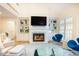 Living room featuring a fireplace with a TV, custom built-ins, large windows, and modern decor at 10 Marchmont Ct, Durham, NC 27705