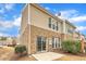 Brick townhouse featuring a sliding glass door leading to a small patio under a partly cloudy sky at 1153 Kingston Grove Dr, Cary, NC 27519