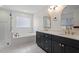 Modern main bathroom featuring a soaking tub, glass shower, dual vanities, and sleek fixtures at 12632 Old Creedmoor Rd, Raleigh, NC 27613