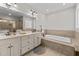 Bathroom featuring double vanity, soaking tub, and a separate tiled shower at 1328 Wakefield Farm Rd, Zebulon, NC 27597