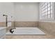 This modern soaking tub is set within neutral tiling and a privacy window at 1328 Wakefield Farm Rd, Zebulon, NC 27597