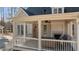 Elegant covered porch featuring a cozy outdoor seating area and a fireplace at 1328 Wakefield Farm Rd, Zebulon, NC 27597
