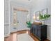 Bright foyer boasts hardwood floors, black storage cabinet, and stylish mirrors at 1328 Wakefield Farm Rd, Zebulon, NC 27597