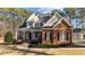 Inviting two-story home featuring a charming front porch and manicured landscaping at 1328 Wakefield Farm Rd, Zebulon, NC 27597