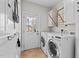 Well-lit laundry room featuring a washer, dryer, and storage cabinets at 1328 Wakefield Farm Rd, Zebulon, NC 27597
