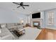 Open living room features a fireplace, mounted TV, and neutral colored furniture at 1328 Wakefield Farm Rd, Zebulon, NC 27597