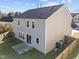 Aerial view of the rear exterior with gray siding, dark roof, and a small patio at 1510 Roaring Rapids Rd, Raleigh, NC 27610