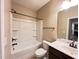 Neutral bathroom featuring a white tub/shower combo, dark fixtures, and a dark vanity with a white sink at 1546 Tinos Overlook Way, Apex, NC 27502