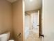 Bathroom showcasing a tub/shower combo, toilet, and doorway to another room in a neutral color scheme at 1546 Tinos Overlook Way, Apex, NC 27502