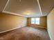 Spacious bedroom featuring neutral walls and carpeting with a modern tray ceiling and ample natural light at 1546 Tinos Overlook Way, Apex, NC 27502