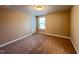 Bedroom with neutral walls and carpeting, a window for natural light, and a classic white door at 1546 Tinos Overlook Way, Apex, NC 27502