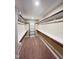 Organized walk-in closet with built-in shelving and rods for ample storage, plus neutral carpet at 1546 Tinos Overlook Way, Apex, NC 27502
