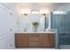 A bathroom features double sinks, a glass shower with blue subway tile, and modern fixtures at 1733 Deacon Falls Way, Wendell, NC 27591