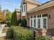 Close-up of brick home featuring manicured bushes, black railing, and a private patio area at 200 Valleyshire Rd, Durham, NC 27707