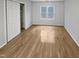A bedroom with hardwood floors, closet, and a bright window letting in lots of natural light at 206 Collegiate Cir, Durham, NC 27713